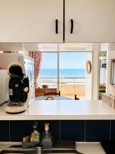 a kitchen with a view of the ocean at Studio cabine pied dans l eau climatisé, parking et wifi haut débit in Canet-en-Roussillon