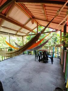 eine Hängematte in einem Pavillon mit Tischen und Stühlen in der Unterkunft Hospedaje Rural Shihumar in Coquí