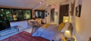 a bedroom with a bed and a living room at Au fil de l'eau in Chambonas +18 photos