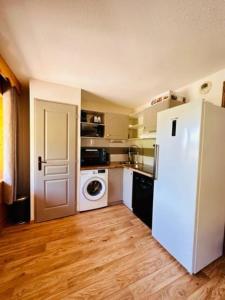 a kitchen with a refrigerator and a washer and dryer at Duplex « les 7 Marmottes », 306 in Chamrousse