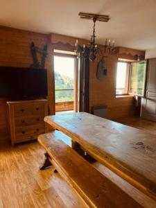 a dining room with a wooden table and a television at Duplex « les 7 Marmottes », 306 in Chamrousse