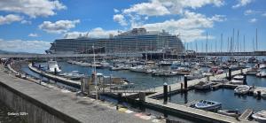 a cruise ship docked in a harbor with boats at Casa da Ermida in Ponta Delgada