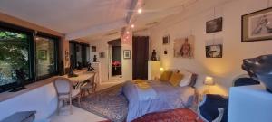 a bedroom with a bed and a table with chairs at Au fil de l'eau in Chambonas