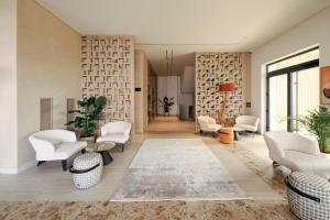 a living room with white chairs and a rug at Sol Boutique Hotel in Vlorë