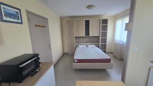 a small bedroom with a bed and a tv at Résidence Mauriac in Mauriac
