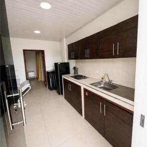 a kitchen with a sink and a refrigerator at Acogedor apartamento in Leticia