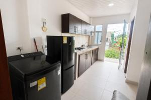 a kitchen with a black refrigerator and a sink at Acogedor apartamento in Leticia