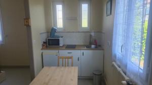 a small kitchen with a table and a microwave at Résidence Mauriac in Mauriac