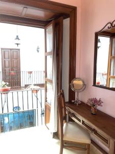 a room with a table and a mirror and a balcony at Casa del Agua in Guanajuato