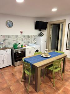 a kitchen with a table and green chairs in a room at DomusVenere in Santa Croce Camerina