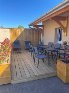 a deck with chairs and tables and a fence at Le Clos d Emilie in Saint-Marcel