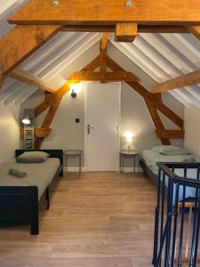 two beds in a room with wooden ceilings at Le Clos d Emilie in Saint-Marcel