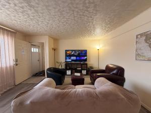 a living room with a couch and a tv at Fireweed Apartments in Fairbanks