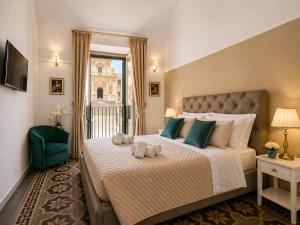 a bedroom with a bed with two towels on it at Immacolata Rooms in Noto