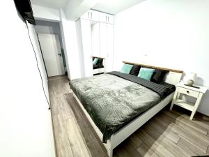 a bedroom with a large bed with a wooden floor at David Apart in Otopeni