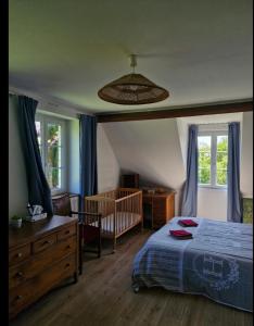 a bedroom with a bed and a crib and windows at Belle maison en pierre, grand jardin au calme in Rocquemont