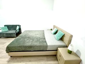 a bedroom with a bed and a chair in it at David Apart in Otopeni +6 photos