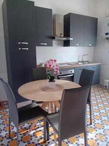 a kitchen with a wooden table with chairs and a table at BGM apartment Rho Fiera Milan in Cesate +17 photos