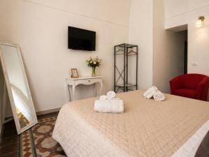 a hotel room with a bed with towels on it at Immacolata Rooms in Noto