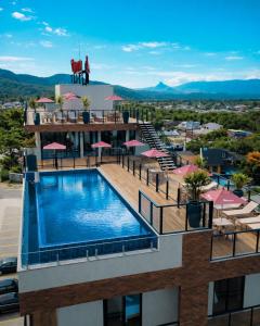 a hotel with a swimming pool on top of a building at MK Flat - A 2 quadras do mar in Matinhos