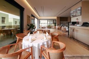 a dining room with tables and chairs and windows at Sol Boutique Hotel in Vlorë