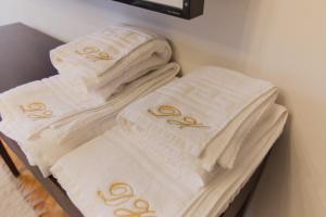 a pile of towels are stacked on a shelf at Dream Home Modern 2BR Apartment Turda Free Parking Near Salina Turda in Turda +30 photos