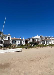 a row of houses on a sandy beach with a blue sky at Casa de playa in Roda de Bará