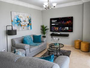 a living room with two couches and a flat screen tv at Brujas Tower Beach Resort in Mazatlán