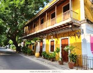 a yellow building with a balcony on a street at De Lemo 3BHK Villa Homestay in Pondicherry