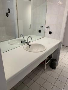 a white bathroom with a sink and a mirror at Appartement Zuiderzeestate Makkum in Makkum +23 photos