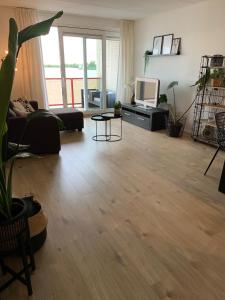 a living room with a couch and a tv at Appartement Zuiderzeestate Makkum in Makkum