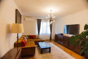 a living room with a couch and a flat screen tv at Dream Home Modern 2BR Apartment Turda Free Parking Near Salina Turda in Turda