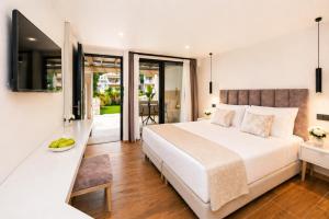 a bedroom with a large white bed and a table at Nobile Boutique Hotel in Agios Gordios +10 photos