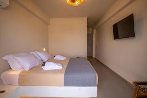 a bedroom with a bed with two towels on it at Onar Hotel Kimolos in Kimolos