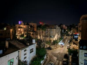 a city street at night with buildings and cars at Friends Hotel Jordan in Amman