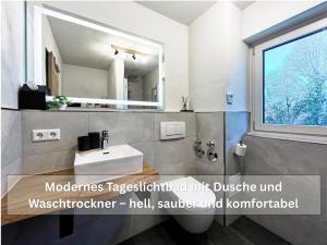 a bathroom with a sink and a mirror at Ruhige Ferienwohnung Seemöwe mit Balkon - ideal für Paare & Radurlauber in Radolfzell am Bodensee