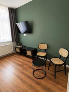 a living room with three chairs and a tv at GuestNest-Erfurt in Erfurt