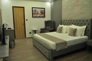 a bedroom with a large bed and a chair at The Royal Palace Inn in Almora