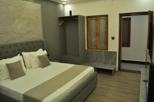 a bedroom with a large bed and a window at The Royal Palace Inn in Almora