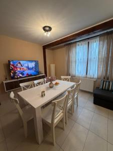 a dining room with a white table and chairs at Cabana Călățele in Călăţele