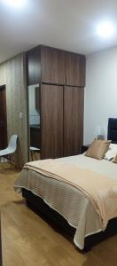 a bedroom with a large bed and wooden cabinets at Disfruta Cala-Cala in Cochabamba