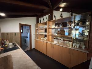 a kitchen with wooden cabinets and shelves with ceramics at Vila Sana in Landeke