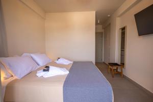 a bedroom with a bed with towels on it at Onar Hotel Kimolos in Kimolos +79 photos