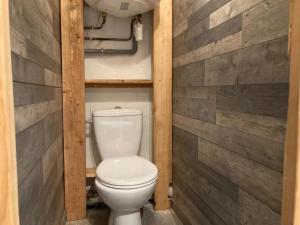 a bathroom with a toilet in a wooden wall at « Le doux Chalet » Roche Béranger in Chamrousse +7 photos