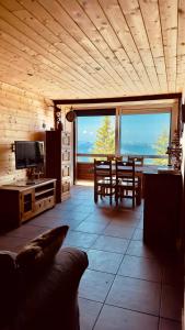 a living room with a table and a view of the ocean at « Le doux Chalet » Roche Béranger in Chamrousse