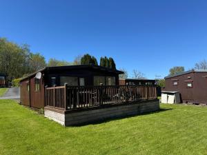 a small building with a fence on a grass field at Lodge 18 - Caer Beris Park - No Tradesmen in Builth Wells