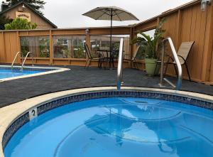 a swimming pool with a table and an umbrella at Lighthouse Pointe Resort in Point Arena