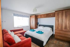 a bedroom with a bed and a red couch at 50 Harbour Road in Bognor Regis