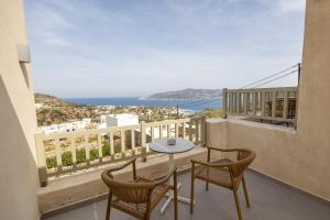 a balcony with a table and chairs and the ocean at Onar Hotel Kimolos in Kimolos