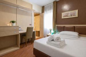 ein Hotelzimmer mit Bett und Schreibtisch in der Unterkunft New Hotel Dulcinea in Muggia